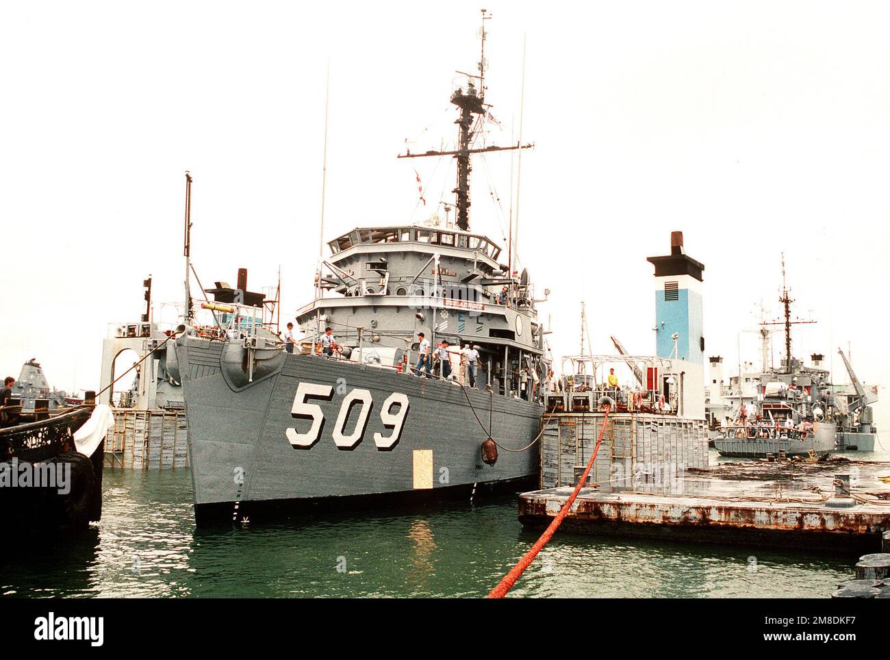 L'ORRIDO USS ADROIT (MSO-509) è spostato sul ponte sommerso della nave pesante olandese SUPER SERVER 3. Tre Stati Uniti I minesweepers dell'oceano della Marina e una nave di contromisure della miniera stanno caricando a bordo del SUPER SERVITORE 3 per il trasporto al golfo persiano, dove sosterranno le forze degli Stati Uniti inviate nella regione in reazione all'invasione dell'Iraq del Kuwait. La portaerei a energia nucleare USS ENTERPRISE (CVN-65) è in secondo piano. Soggetto operativo/Serie: DESERT SHIELD/STORM base: Naval Air Station, Norfolk Stato: Virginia (VA) Paese: Stati Uniti d'America (USA) Foto Stock