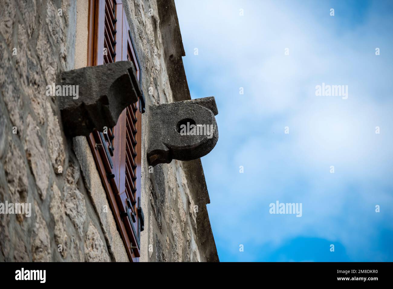 Dettagli in pietra della puleggia fissata sulla facciata di vecchia, casa in pietra in Dalmazia, utilizzato per tirare mobili e oggetti più pesanti all'interno Foto Stock