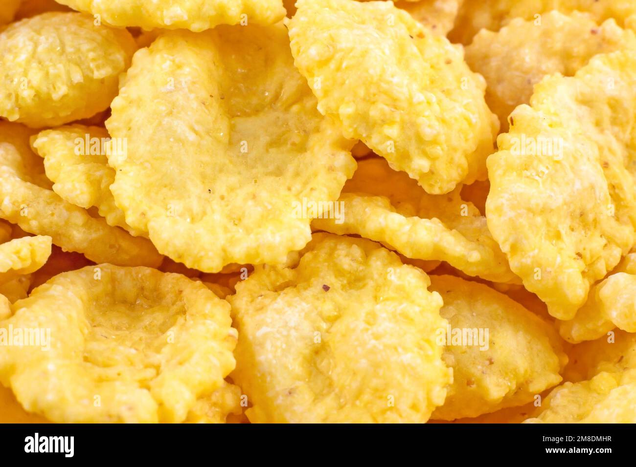Giallo brillante gustoso zucchero croccante cornflakes per colazione come un primo piano consistenza. Foto Stock