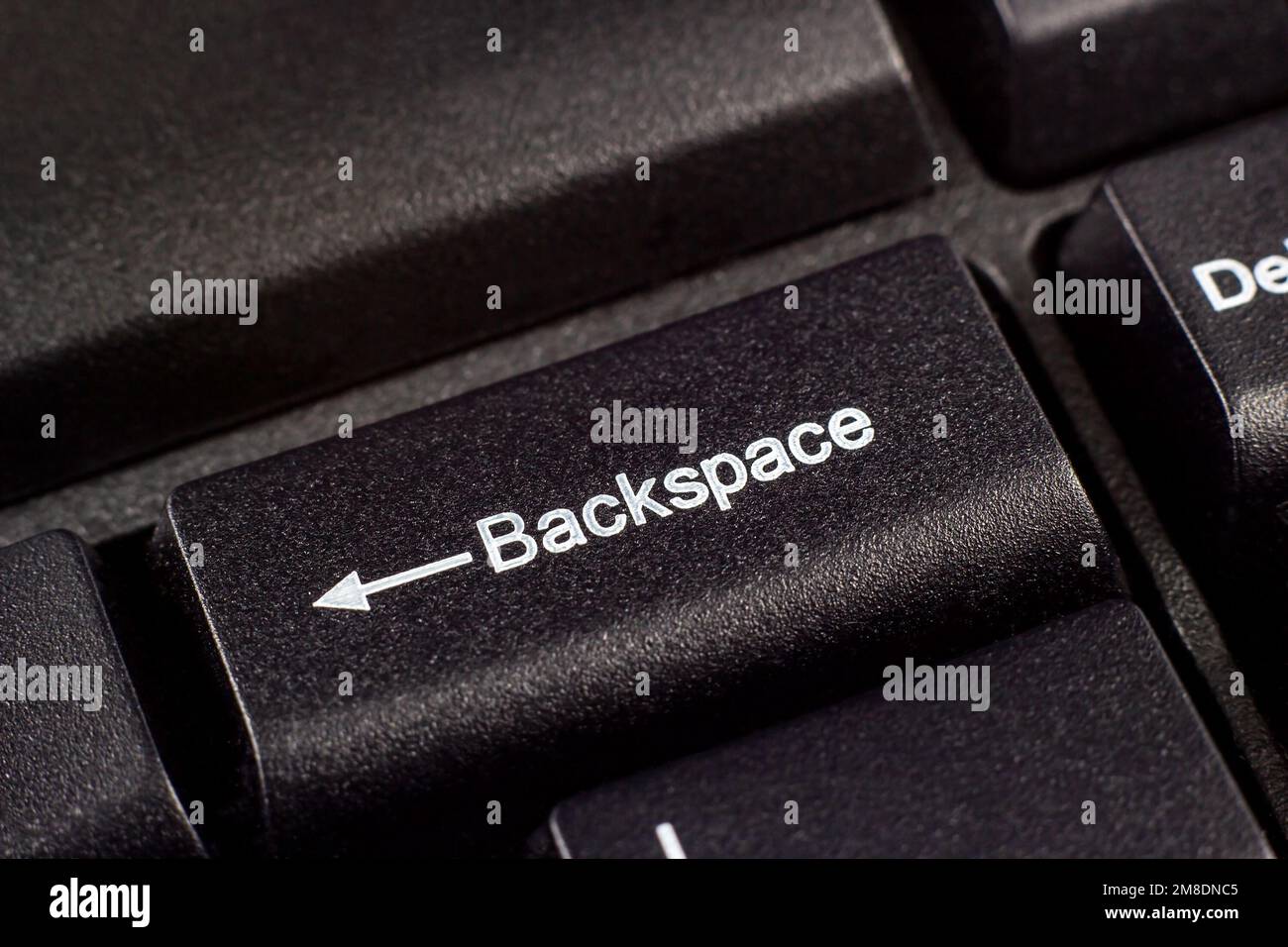 Pulsante del tasto Backspace bianco e nero nella parte superiore della tastiera del computer. Foto Stock