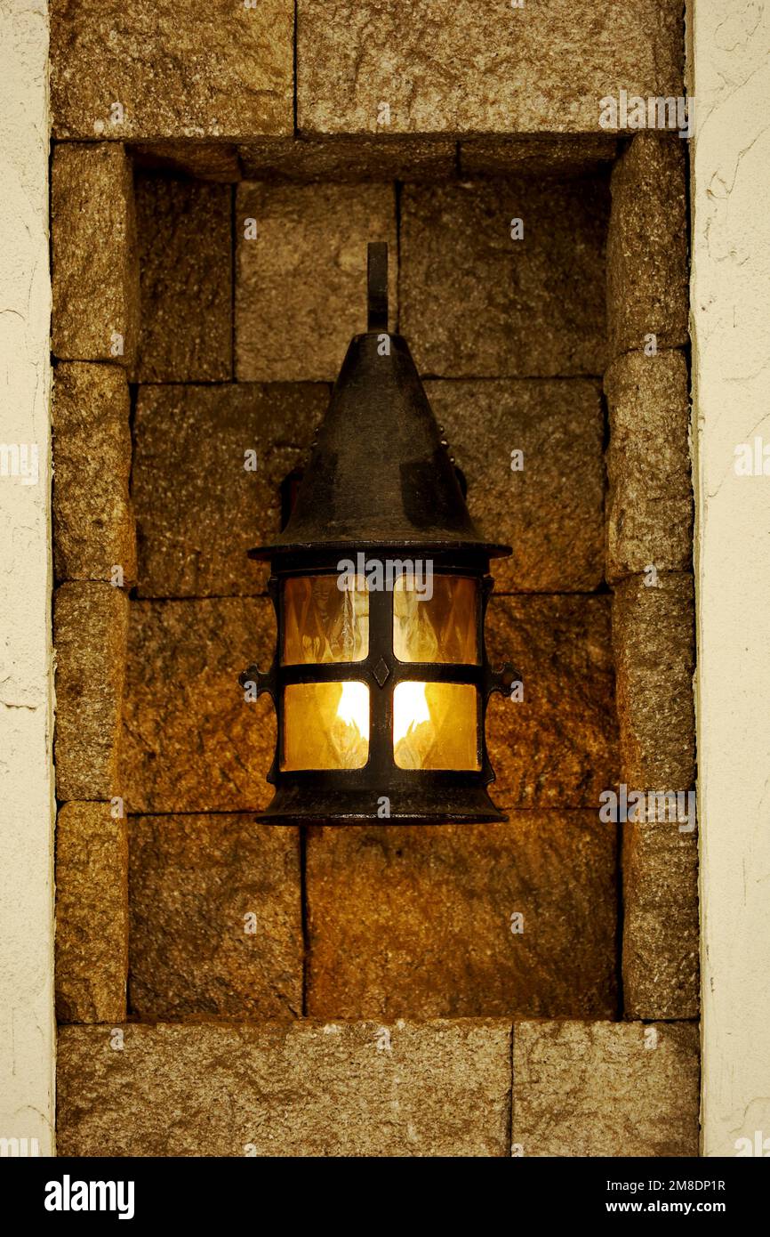 Un'antica lanterna di ferro installata in un edificio in pietra Foto Stock
