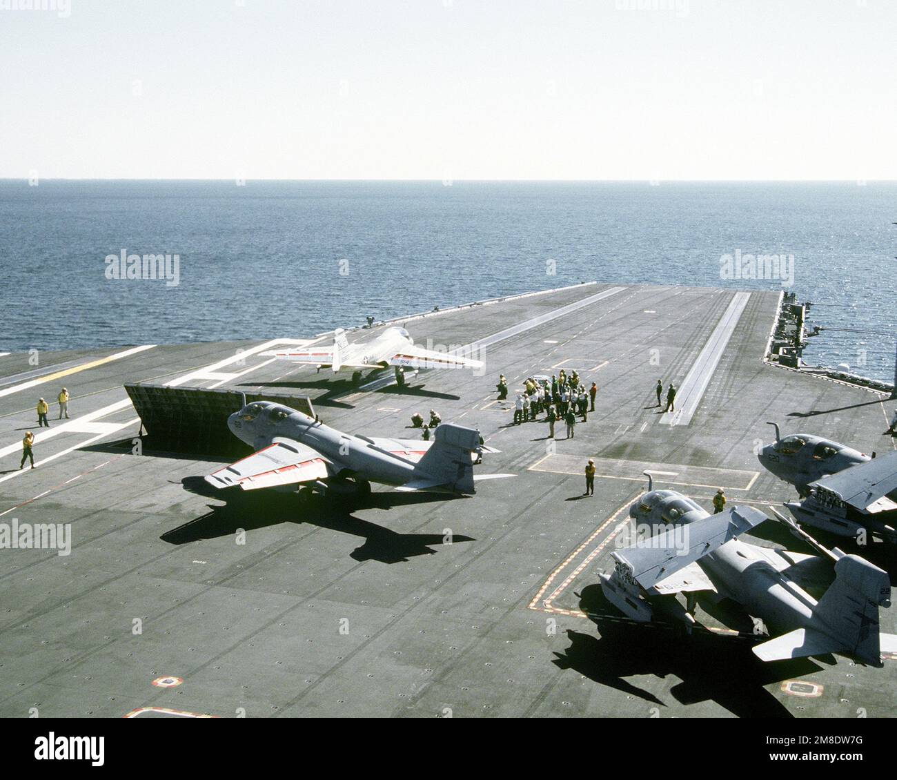 I membri dell'equipaggio del ponte di volo sono in attesa come un attacco Squadron 95 (VA-95) KA-6D l'aereo Intruder viene lanciato dalla catapulta n° 2 sul ponte di volo della portaerei a energia nucleare USS ABRAHAM LINCOLN (CVN-72). Tre aerei Prowler EA-6B Tactical Electronic Warfare Squadron 135 (VAQ-135) sono in piedi per il lancio. Paese: Oceano Atlantico (AOC) Foto Stock