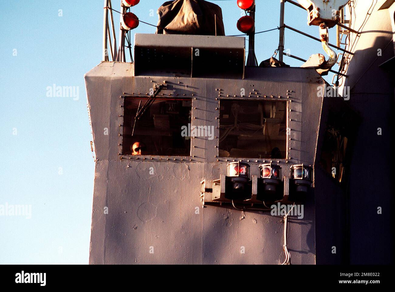 Un ufficiale guarda fuori una finestra della stazione di controllo di volo principale a bordo del molo di trasporto anfibio USS RALEIGH (LPD-1). Il RALEIGH ed i suoi Marines imbarcati sono in mare a sostegno dell'operazione Desert Shield. Soggetto operativo/Serie: SCUDO DEL DESERTO Paese: Mar Arabico Settentrionale Foto Stock