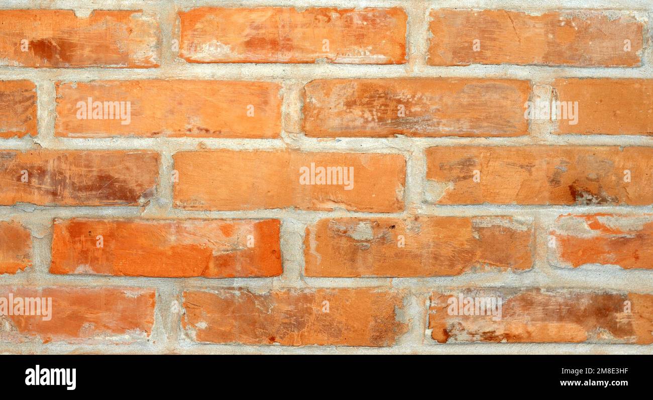 Struttura di fondo di un muro di mattoni rossi con cemento grigio tra loro. Foto Stock