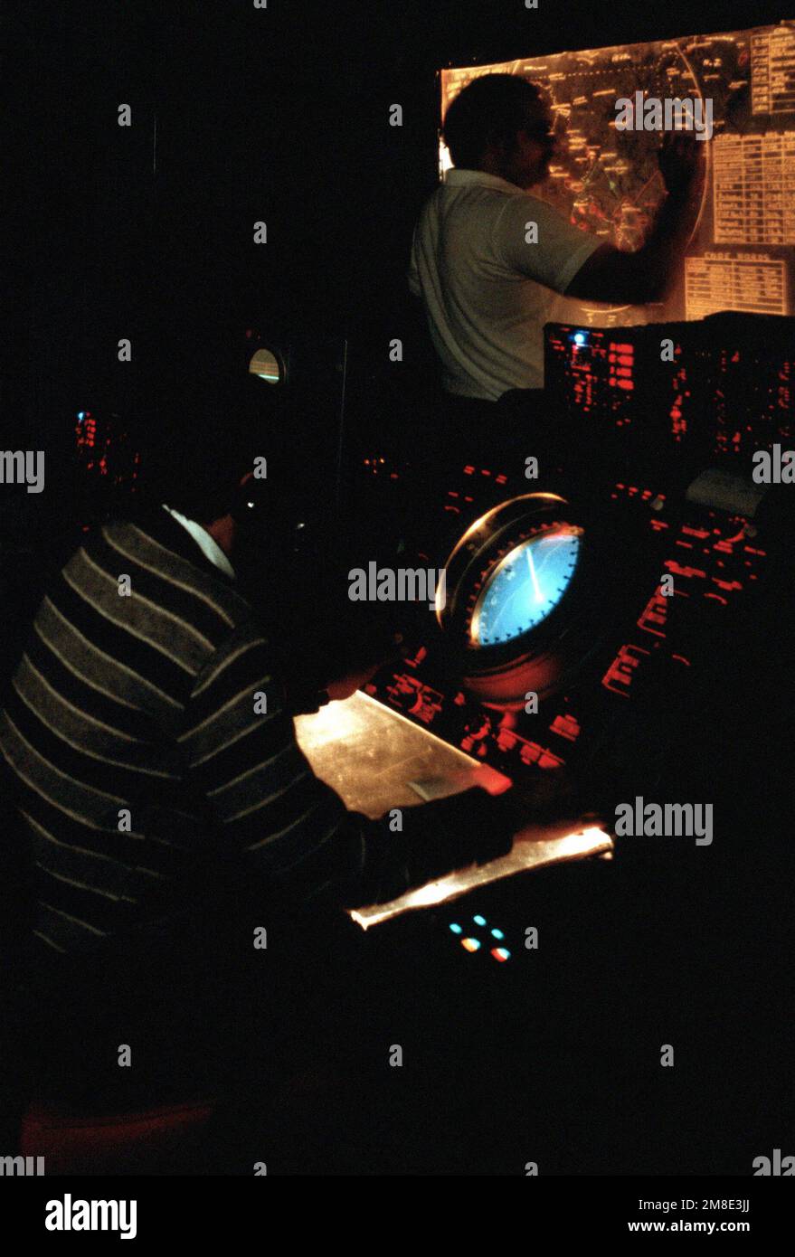 Un tecnico monitora uno schermo radar mentre un altro indica la posizione di un aeromobile su un tabellone di tracciatura nella stazione di interrogatori del Naval Research Laboratory (NRL) Identification Friend o Foe (IFF). L'apparecchiatura IFF della stazione viene utilizzata per sfidare le apparecchiature sperimentali trasportate da aeromobili che volano dalla Naval Air Station, Patuxent River, Maryland, e può anche interrogare tutti gli aeromobili che operano con Mark XII IFF e con il sistema di segnalazione radar per il controllo del traffico aereo civile. Base: Washington Stato: District of Columbia (DC) Nazione: Stati Uniti d'America (USA) Foto Stock