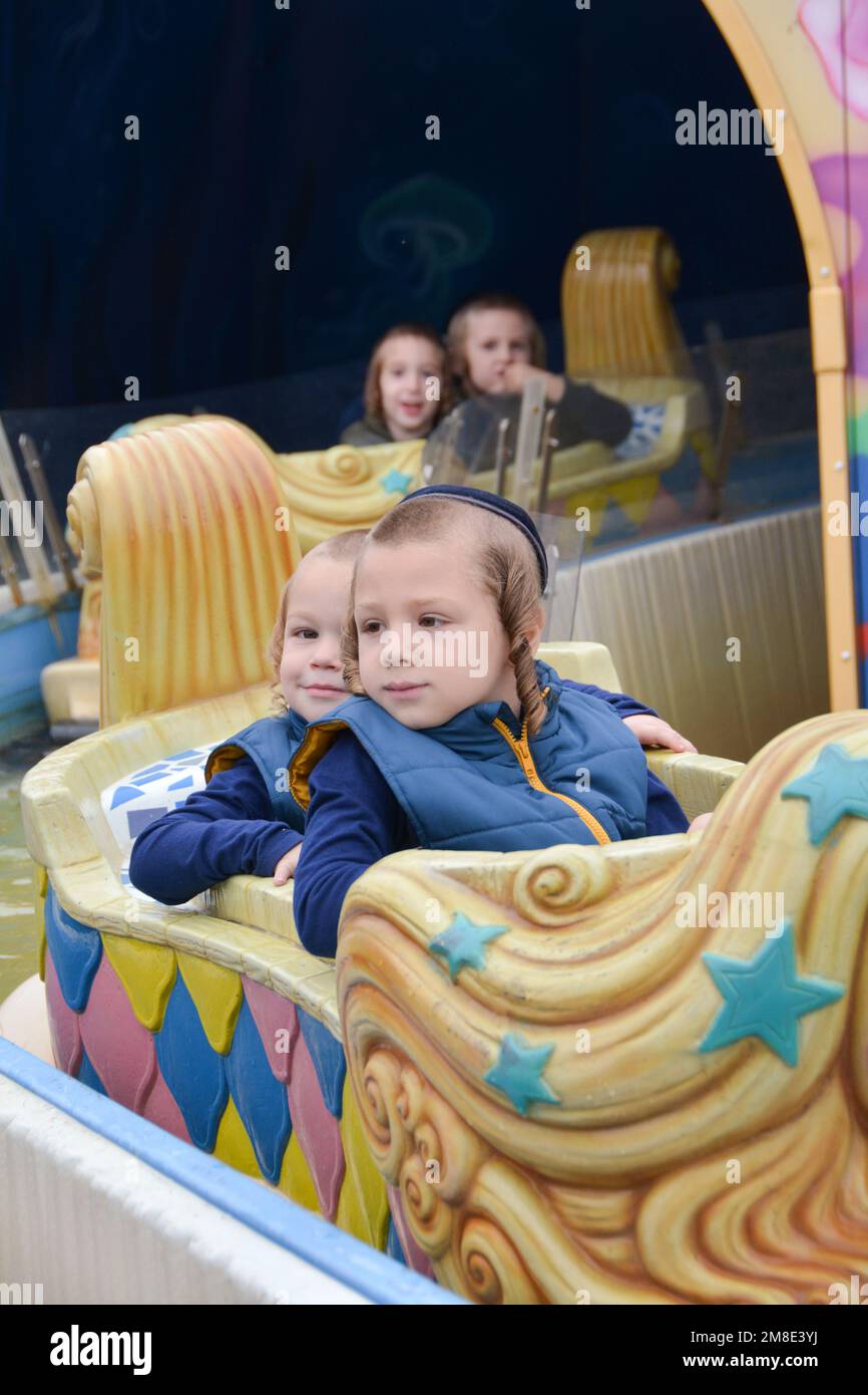 I bambini ebrei ortodossi celebrano la vacanza di Sukkos divertendosi in un parco divertimenti a Luna Park a Coney Island, Brooklyn, New York City. Foto Stock