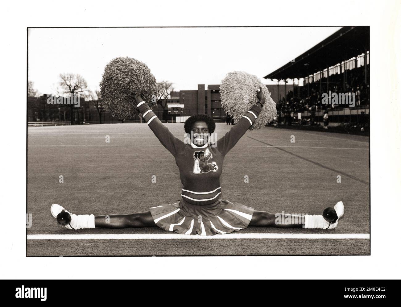 CHRIS. Una cheerleader della Bayside High School fa una split & waves i suoi pom del pom ad una partita di football della PSAL High School nel 1982 Foto Stock