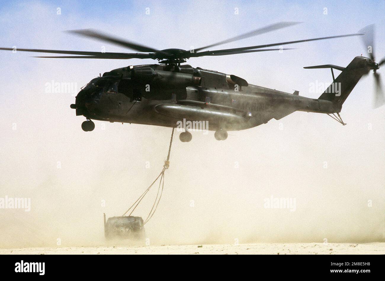 Un elicottero CH-53E Super Stallion abbassa un veicolo gommato multiuso ad  alta mobilità M-998 in una zona di atterraggio durante l'esercizio  imminente Thunder, parte dell'operazione Desert Shield. Soggetto  operativo/Serie: IMMINENTE scudo THUNDERDESERT