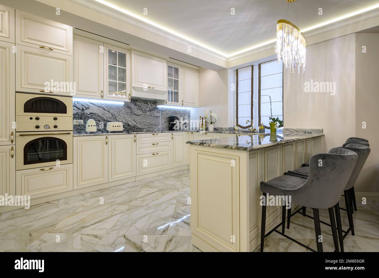 Cucina classica color crema con isola usata come zona pranzo in  appartamento monolocale Foto stock - Alamy
