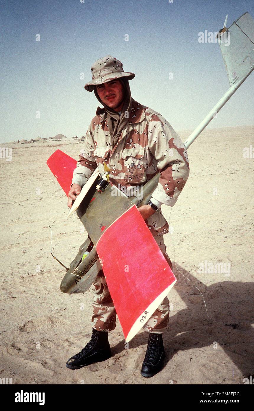 Un Marine trasporta un drone radiocontrollato che è stato leggermente danneggiato all'atterraggio in un luogo nel nord dell'Arabia Saudita durante l'operazione Desert Storm. Soggetto operativo/Serie: TEMPESTA DEL DESERTO Paese: Arabia Saudita (SAU) Foto Stock