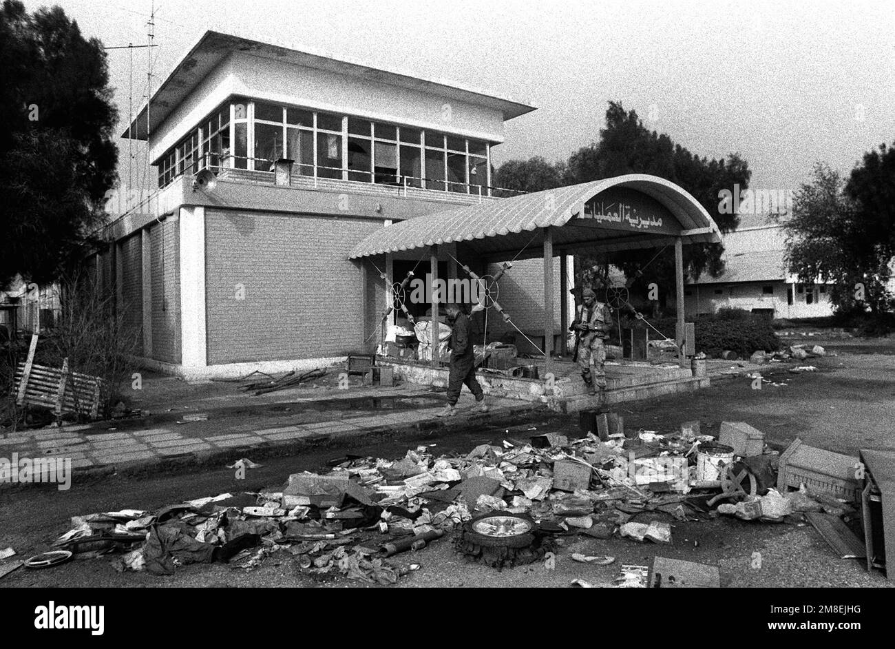 I detriti coprono la strada di fronte a un edificio assicurato dalle truppe di coalizione in seguito al ritiro delle forze irachene dalla città durante l'operazione Desert Storm. Subject Operation/Series: DESERT STORM base: Kuwait City Nazione: Kuwait (KWT) Foto Stock