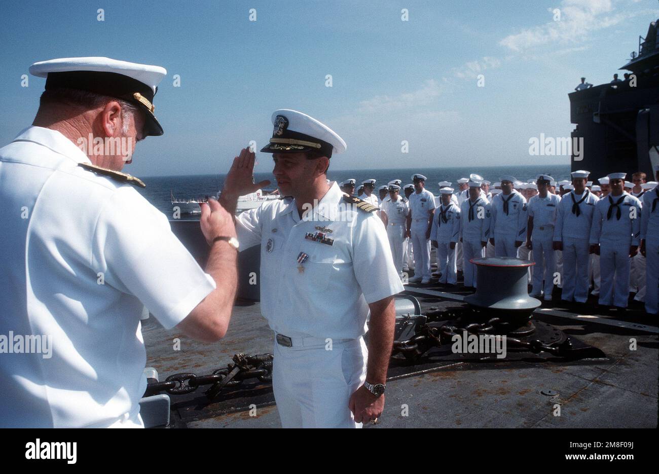 CMDR. Dennis G. Morral, comandante della fregata missilistica guidata USS NICHOLAS (FFG-47), saluta IL CAPO delle operazioni Navali ADM. Frank B. Kelso II, partito, dopo essere stato presentato con una medaglia d'argento Star durante una cerimonia di premiazione a bordo della nave. IL NICHOLAS sta ritornando al suo porto natale della Stazione Navale, Charleston, S.C., dopo il suo spiegamento nella regione del Golfo Persico per l'operazione Desert Shield e l'operazione Desert Storm. Soggetto operativo/Serie: DESERTO SCUDO TEMPESTA DESERTO Paese: Oceano Atlantico (AOC) Foto Stock