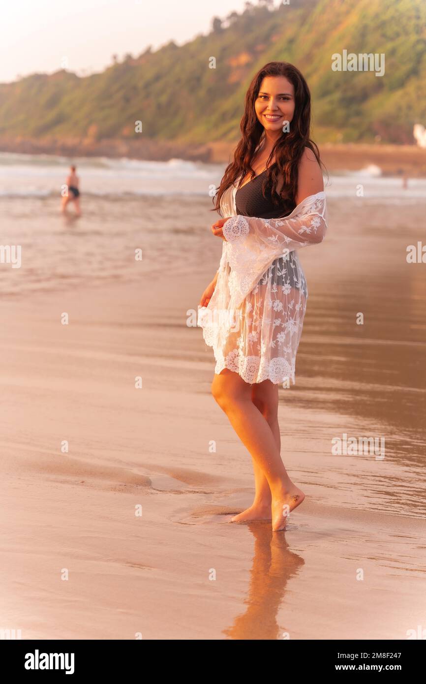 Ritratto di una donna al tramonto in un vestito bianco godendo le vacanze Foto Stock