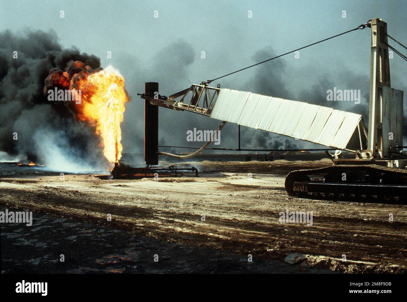 Vigili del fuoco di The Boots and Coots Oil Well Firefighting Company si preparano a posizionare un cappello su un pozzo di fuoco nel periodo successivo a Operation Desert Storm. Il pozzo, situato nei campi di petrolio di Ahman, è uno dei tanti posti in preda alle forze irachene prima del loro ritiro dal Kuwait. Subject Operation/Series: DESERT STORM base: Ahman Oil Fields Paese: Kuwait(KWT) Foto Stock