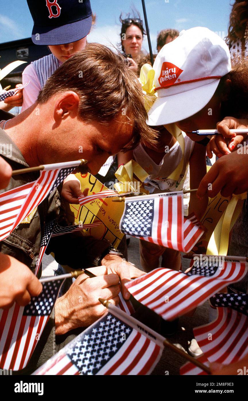 MAJ. Mark Hefferly, un pilota dello Squadrone di ricostruzione tattica 12th, 67th Tactical Reconnaissance Wing, firma autografi per la quarta classe di suo figlio durante i festeggiamenti di benvenuto per lui e gli equipaggi di quattro aerei RF-4C Phantom II. L'aeromobile è stato dispiegato nel gennaio 10 a sostegno dell'operazione Desert Storm. Soggetto operativo/Serie: DESERT STORM base: Bergstrom Air Force base Stato: Texas(TX) Paese: Stati Uniti d'America (USA) Foto Stock