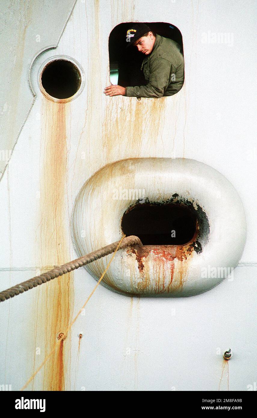 Un membro dell'equipaggio controlla una linea di ormeggio mentre la portaerei USS AMERICA (CV-66) attracca in porto. L'AMERICA è appena tornata a Norfolk in seguito al dispiegamento nell'area del Golfo Persico durante l'operazione Desert Storm. Soggetto operativo/Serie: DESERT STORM base: Naval Air Station, Norfolk Stato: Virginia (VA) Paese: Stati Uniti d'America (USA) Foto Stock