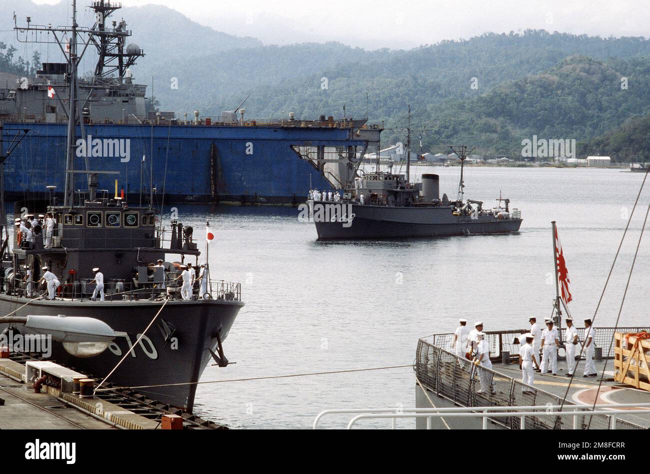 La forza di autodifesa marittima giapponese Minehunter/spazzatrice costiera AWASHMA (MSC-670), a sinistra, e la nave di supporto per le spazzatrici meno ripide HAYASE (MST-462) si legano al molo mentre la cacciatrice/spazzatrice costiera YURISHIMA (MSC-668) si avvicina al suo ormeggio. Tre minatori giapponesi e due navi di sostegno si fermano nelle Filippine mentre si dirigono verso il Kuwait per assistere nello sforzo multinazionale di liberare le miniere irachene dal Golfo Persico dopo l'operazione Desert Storm. Subject Operation/Series: DESERT STORM base: Naval Station, Subic Bay Stato: Luzon Paese: Filippine (PHL) Foto Stock