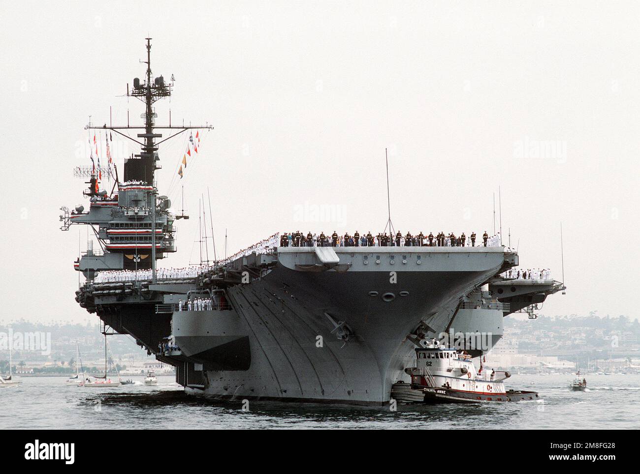 I membri dell'equipaggio immanettono le rotaie a bordo della portaerei USS RANGER (CV-61) come porto commerciale rimorchiano la nave in porto. Il RANGER sta ritornando alla Stazione Navale di North Island dopo essere stato dispiegato nell'area del Golfo Persico durante l'operazione Desert Storm. Soggetto operativo/Serie: DESERT STORM base: San Diego Stato: California(CA) Paese: Stati Uniti d'America (USA) Foto Stock