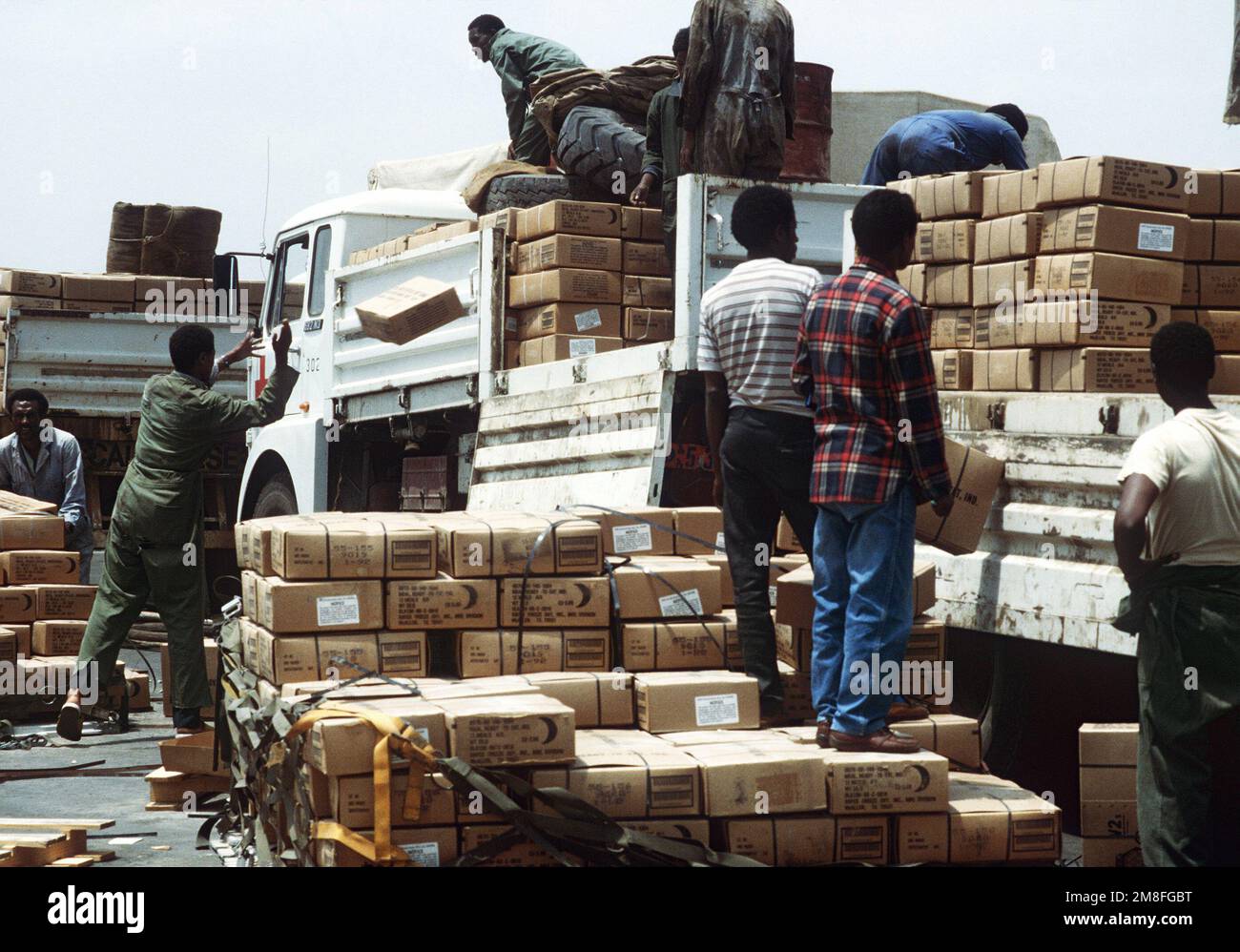 I lavoratori caricano scatole contenenti pasti pronti per mangiare (MREs) su un camion della Croce Rossa dopo che le forniture sono state consegnate in Etiopia dal comando militare di sollevamento aereo C-5A Galaxy. La Croce Rossa consegnerà le REM ai rifugiati che soffrono a causa dei disordini civili dell'Etiopia. Gli MREs sono forniture militari in eccesso e sono messi a disposizione dall'autorità del programma McCallum e del programma DOD Excess Property. Base: Addis Ababa Paese: Etiopia(ETH) Foto Stock