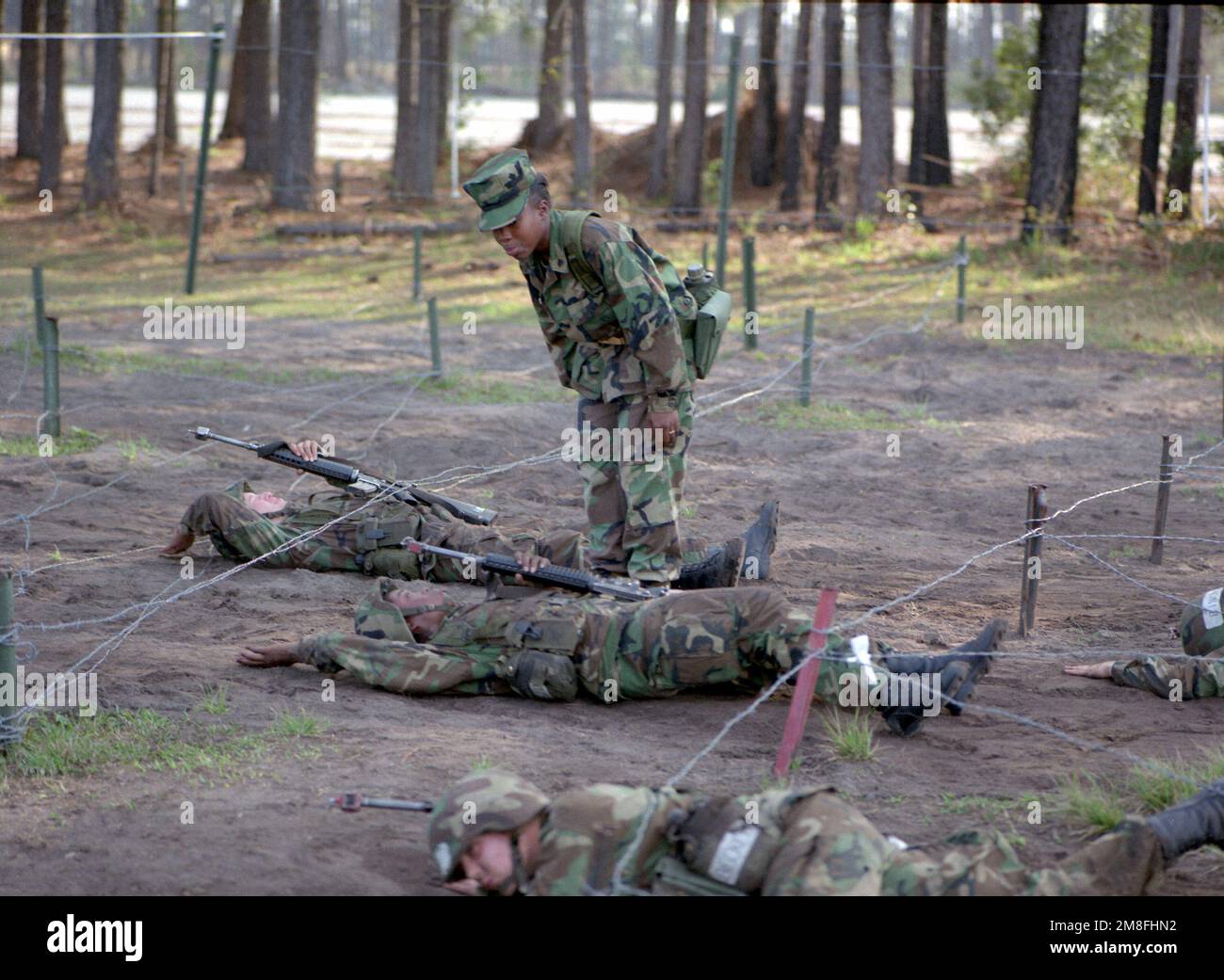 Un battaglione 4th reclutato negozia un ostacolo filo spinato mentre un istruttore di perforazione guarda. Il battaglione 4th è l'unica unità femminile del corpo dei Marine. Base: MC Recruit Depot, Isola di Parigi Stato: South Carolina (SC) Paese: Stati Uniti d'America (USA) Foto Stock