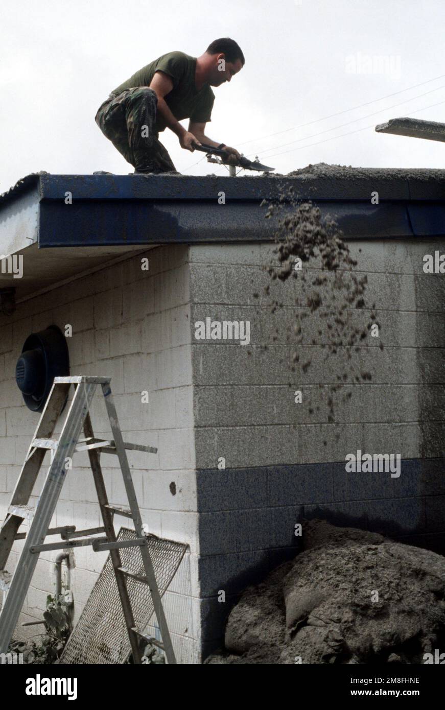 Un Marine utilizza il suo strumento di intrappolamento per eliminare la cenere dal tetto della cucina di cubi Point. Quattro pollici di cenere vulcanica caddero sulla zona dopo l'eruzione del Monte Pinatubo. Base: Naval Station, Subic Bay Stato: Luzon Paese: Philippines(PHL) Foto Stock