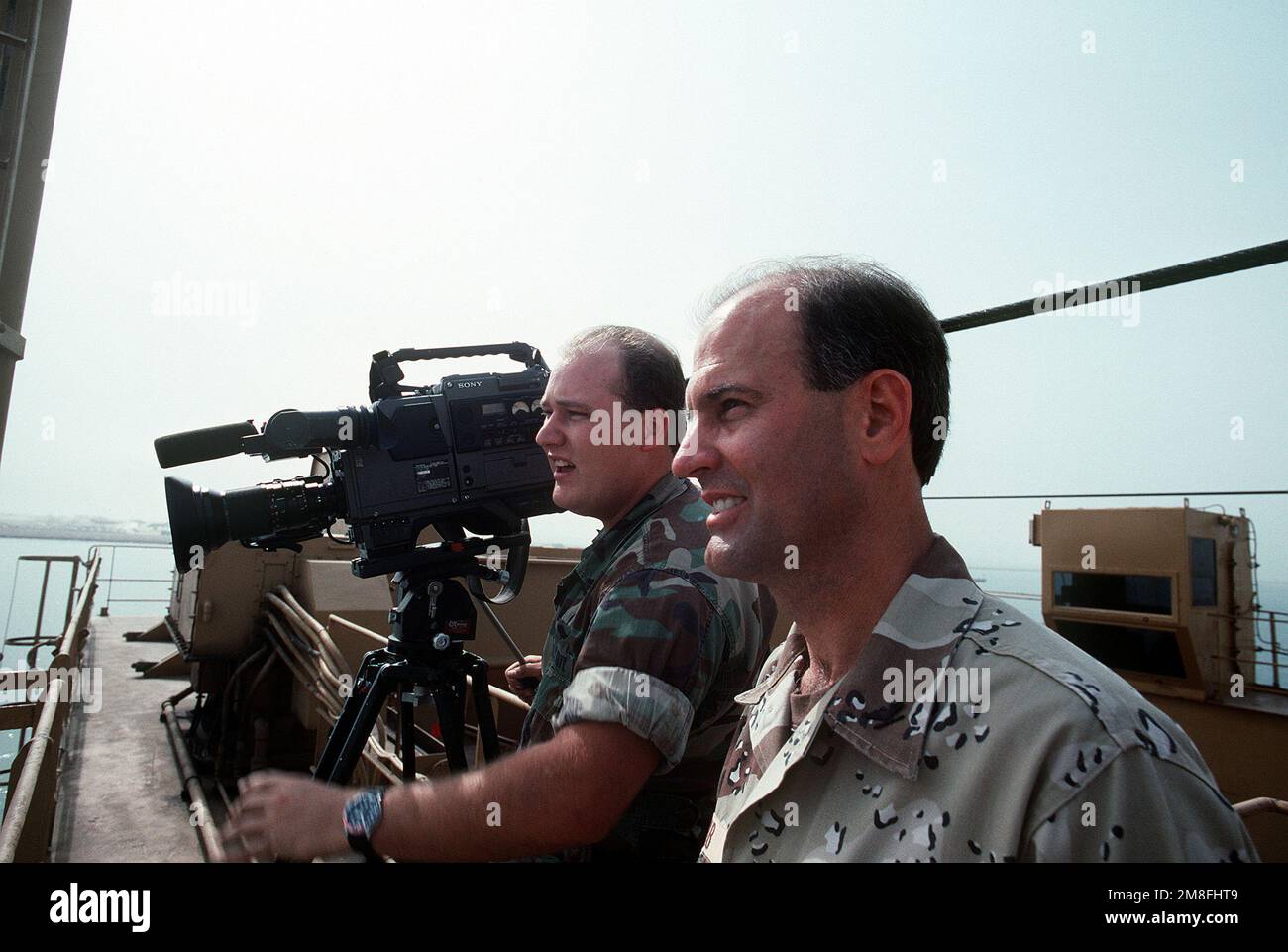 Un video cameraman film operazioni come ordnance e attrezzature è caricato a bordo di navi militari Sealift Command veicolo di carico per la ridistribuzione negli Stati Uniti in seguito a operazione Desert Storm. Soggetto operativo/Serie: TEMPESTA DEL DESERTO Paese: Arabia Saudita (SAU) Foto Stock