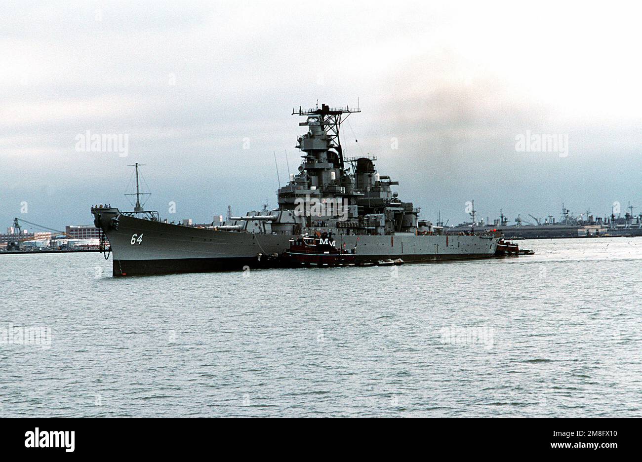 Tre rimorchiatori commerciali aiutano a spostare la corazzata MESSA fuori servizio WISCONSIN (BB-64) nel porto. Il WISCONSIN verrà trainato fino al cantiere navale di Philadelphia, Pennsylvania. Base: Naval Air Station, Norfolk Stato: Virginia(VA) Paese: Stati Uniti d'America (USA) Foto Stock