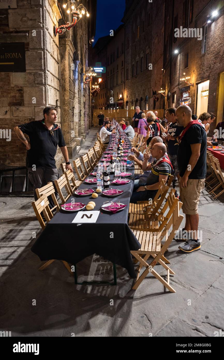 Siena, Italia - 15 2022 agosto: La cena in Grande Contrada del Civetta o piccola gufo Contrada la sera prima del Palio dell'Assunta in Piazza To Foto Stock