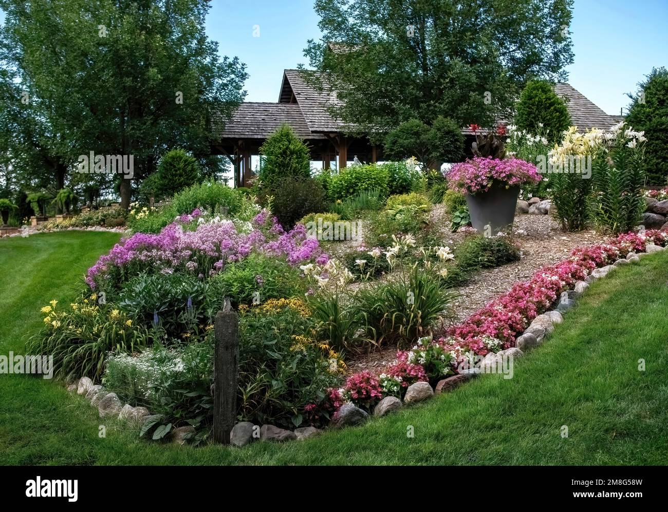 Bel giardino formale con gigli, flox, begonie, petunie e altri fiori ai Giardini della Valle di Panola; un luogo di nozze a Lindstrom, Minn. STATI UNITI Foto Stock