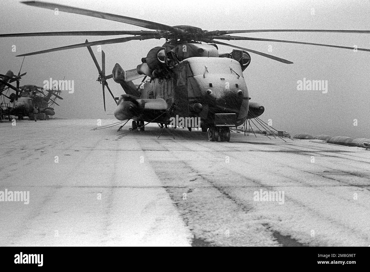 Un elicottero CH-53E Super Stallion innevato siede assicurato sul ponte di volo della nave d'assalto anfibia USS GUADALCANAL (LPH-7) mentre la forza del ponte libera il ponte prima che le operazioni di volo possano iniziare. La USS GUADALCANAL si trova nella regione baltica e partecipa all'esercitazione Teamwork '92. Soggetto operativo/Serie: LAVORO DI SQUADRA '92 Paese: Mare di Norvegia Foto Stock