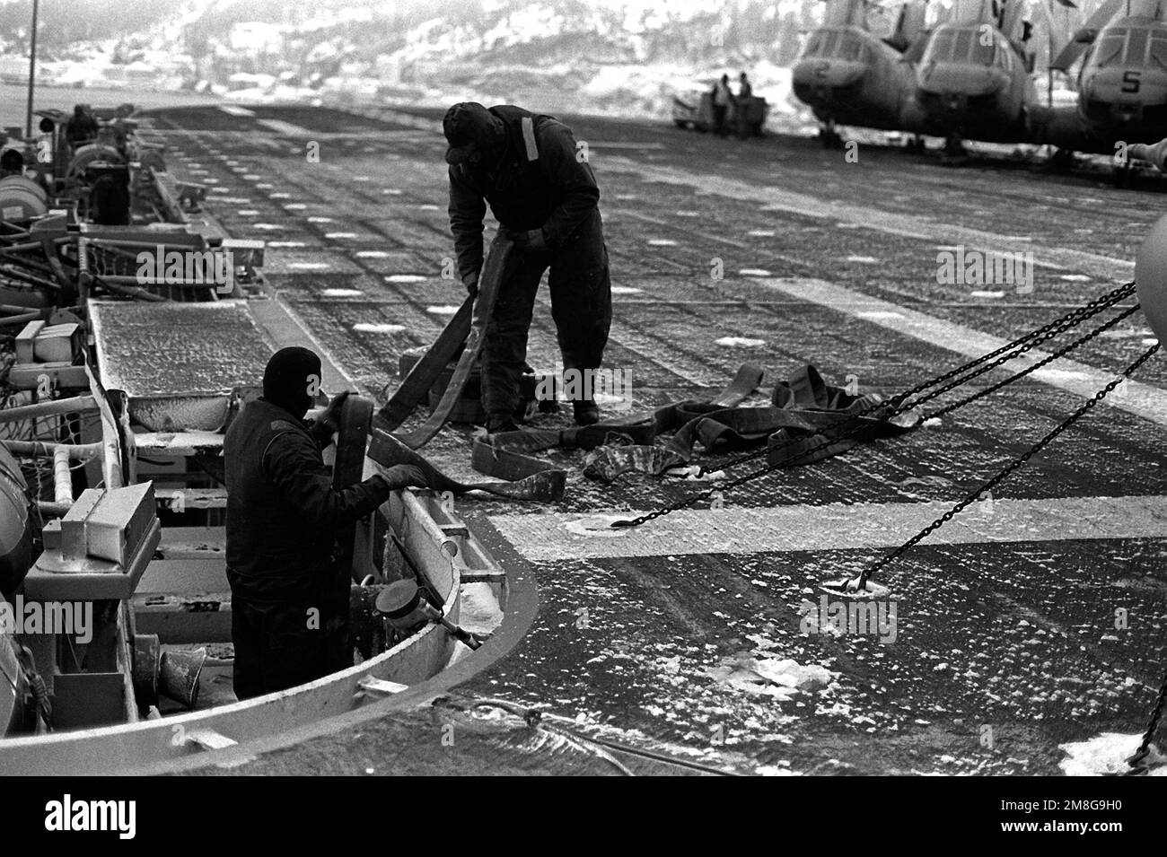 I membri della forza ponte della nave d'assalto anfibia USS GUADALCANAL (LPH-7) immagazzinano manichette e altri attrezzi dopo aver riposto il ponte di volo di neve in modo che la nave possa riprendere le normali operazioni di volo. La USS GUADALCANAL si trova nel Baltico e partecipa all'esercitazione Teamwork '92. Soggetto operativo/Serie: LAVORO DI SQUADRA '92 Paese: Mare di Norvegia Foto Stock