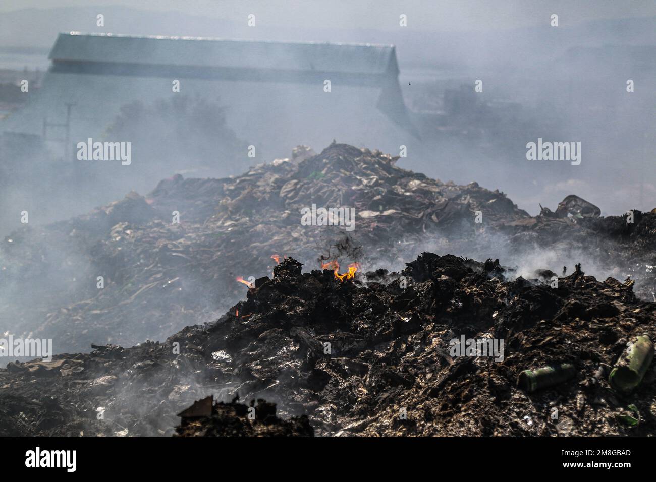 Una vista di un'area con fumo pesante da rifiuti bruciati presso il cantiere di scarico principale di Nakuru. Poiché i rifiuti sono raramente segregati ed è fortemente mescolati con tutti i tipi di rifiuti, bruciarli può produrre fumi potenzialmente tossici che possono essere un problema di salute pubblica e possono anche contribuire al cambiamento climatico. Le comunità che lavorano e vivono in prossimità di siti di scarico in cui la spazzatura viene apertamente bruciata rischiano di contrarre malattie respiratorie e tumori. Le donne esposte a tali fumi possono soffrire di problemi di salute riproduttiva. (Foto di James Wakibia/SOPA Images/Sipa USA) Foto Stock