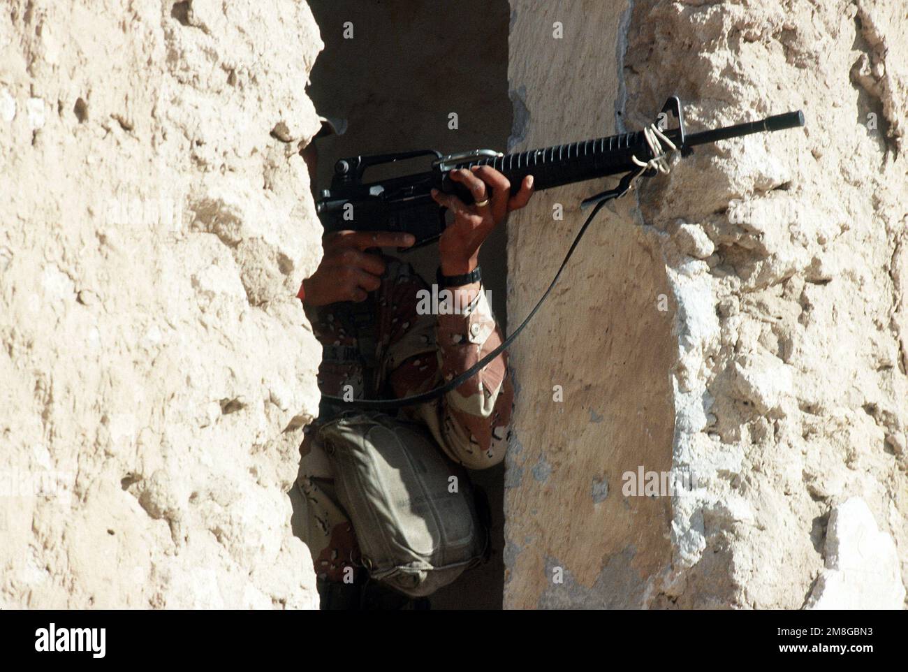 Un soldato della Co.. A, 3rd BN., 502nd INF. Regt., 101st Airborne Div., punta il suo fucile M-16A2 partecipando a un allenamento di guerra urbano in una città abbandonata durante l'operazione Desert Shield. Subject Operation/Series: SCUDO DEL DESERTO Paese: Arabia Saudita (SAU) Foto Stock