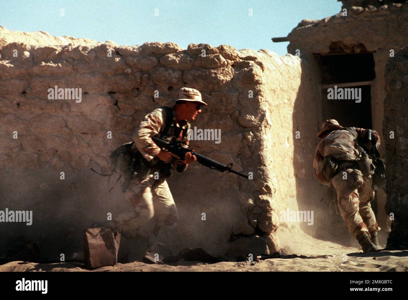 Soldati di Co.. A, 3rd BN., 502nd INF. Reg., immettere un composto in una città abbandonata. Gli uomini, armati di fucili M-16A2, partecipano a un allenamento di guerra urbano durante l'operazione Desert Shield. Subject Operation/Series: SCUDO DEL DESERTO Paese: Arabia Saudita (SAU) Foto Stock