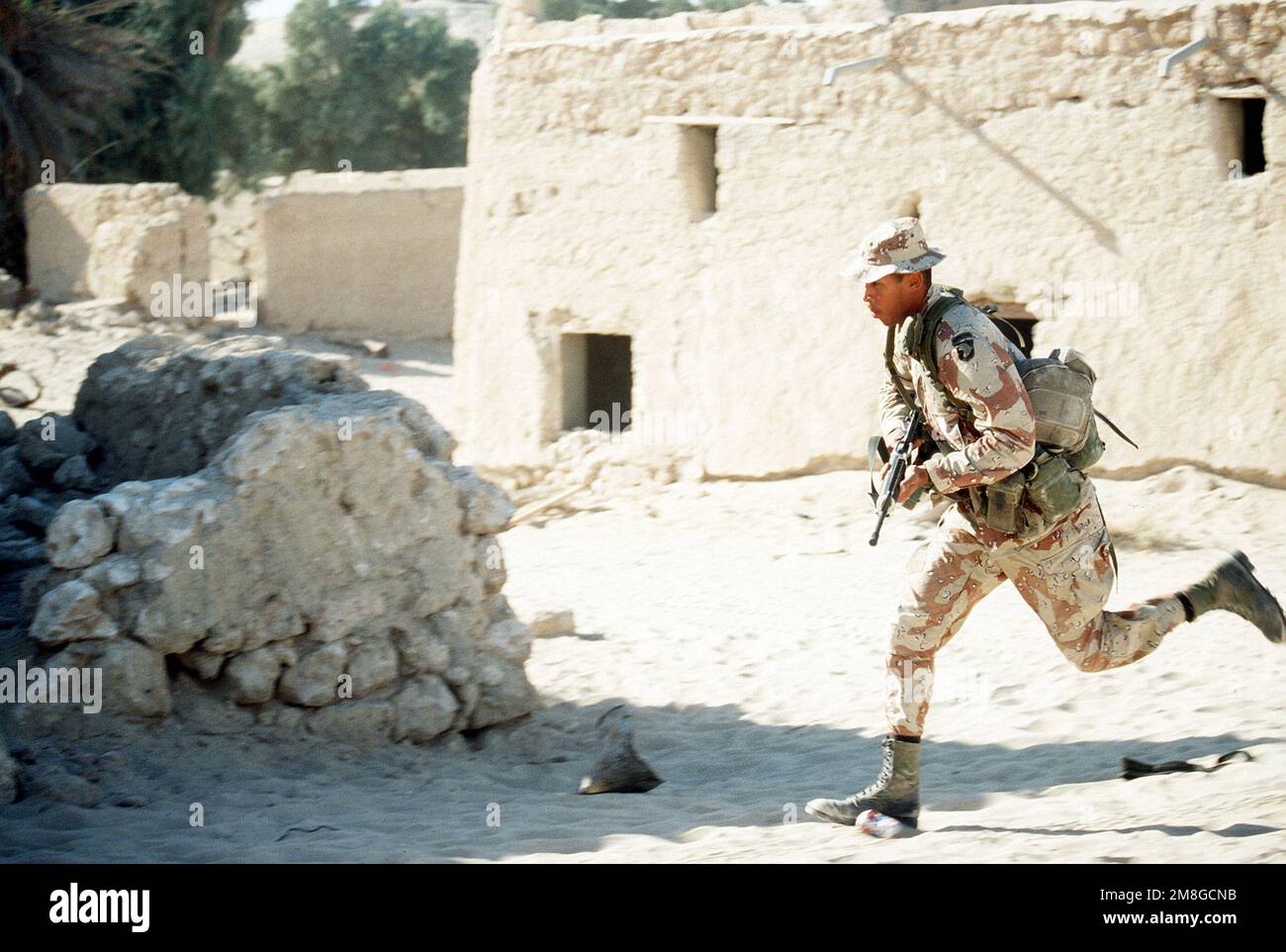 Un soldato di Co.. A, 3rd BN., 502nd INF. Regt., 101st Airborne Div., corre per copertura mentre partecipa ad un esercizio di addestramento di guerra urbano che è messo in scena in una città abbandonata durante l'operazione Desert Shield. Subject Operation/Series: SCUDO DEL DESERTO Paese: Arabia Saudita (SAU) Foto Stock