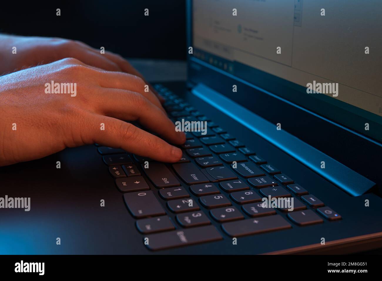 Mani di un uomo che digita sulla tastiera di un notebook. Un uomo che lavora su un notebook. Messa a fuoco selettiva Foto Stock