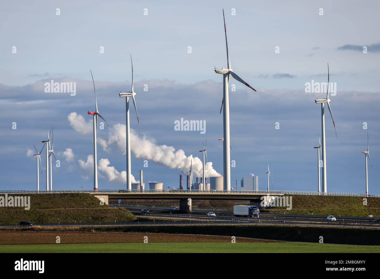 Jackerath, Renania settentrionale-Vestfalia, Germania - Fattoria eolica di fronte alla centrale elettrica di Neurath della RWE presso lo svincolo autostradale di Jackerath, potenza a lignite Foto Stock