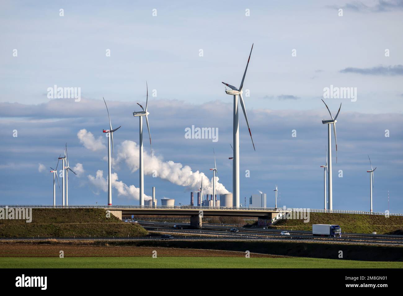 Jackerath, Renania settentrionale-Vestfalia, Germania - Fattoria eolica di fronte alla centrale elettrica di Neurath della RWE presso lo svincolo autostradale di Jackerath, potenza a lignite Foto Stock