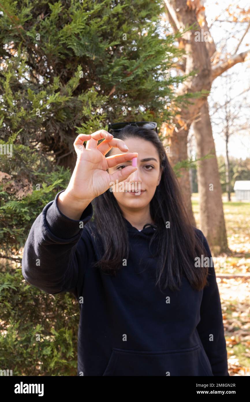 Donna che mostra la medicina, la vitamina, la pillola dietetica o l'idea di concetto della capsula con lo spazio della copia. Integratori alimentari, trattamento. Stile di vita sano. Foto Stock