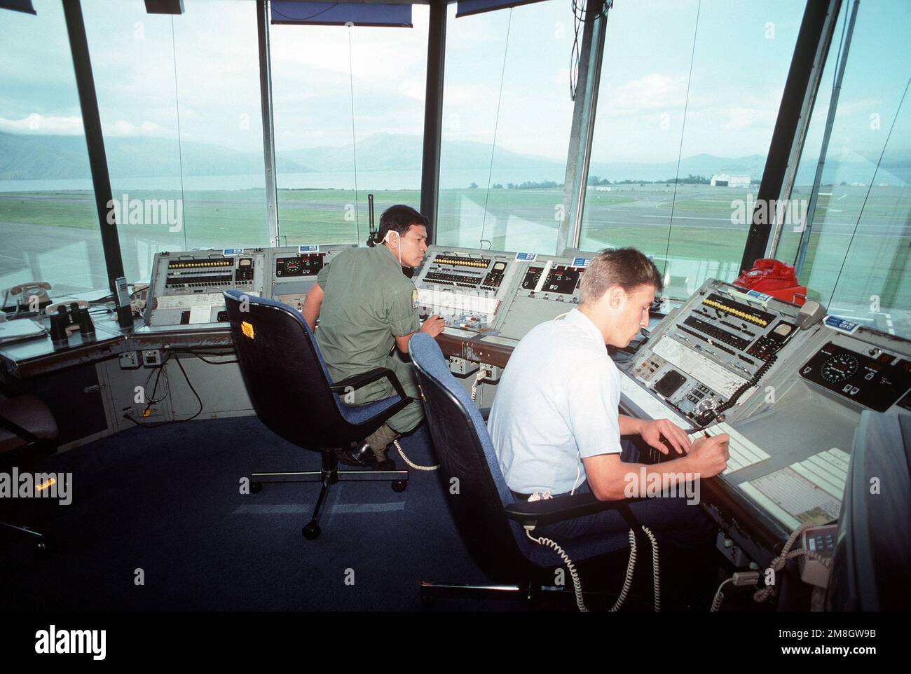 SSGT Roque Exconde della forza aerea filippina, a sinistra, e Air Controlman 2nd Classe John Kahr monitorare l'aereo in arrivo alla torre di controllo di Cubi Point negli ultimi giorni della presenza militare degli Stati Uniti presso la struttura. Il controllo di NAS, Cubi Point e della Stazione Navale, Subic Bay, è stato riconpassato al governo filippino. Base: Naval Air Station, Cubi Point Stato: Luzon Paese: Filippine (PHL) Foto Stock