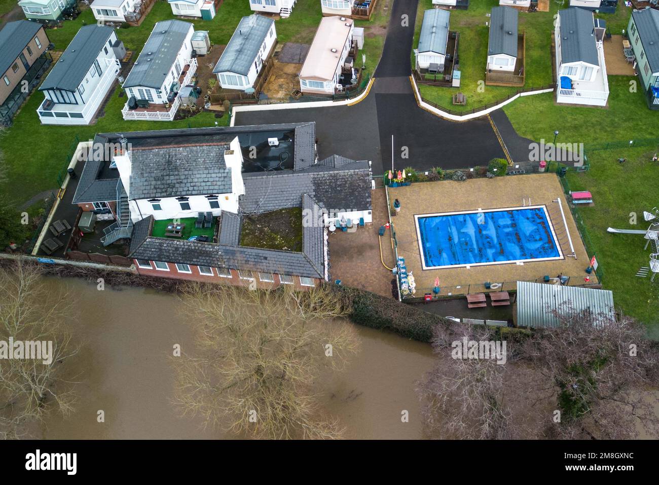 Stourport su Severn, Worcestershire, 14 gennaio 2023 - i siti di carovane lungo il fiume Severn a Stourport su Severn sono stati inondati a causa dell'aumento dell'acqua dopo che il fiume ha scoppiato le sue rive. Una fila di case sul fiume e una piscina per il tempo libero del parco sono mantenute asciutte a causa delle barriere alluvionali e delle pompe dell'acqua. Si prevede che il fiume si innalzi ulteriormente e raggiunga il picco la domenica mattina presto. Credito: Interrompi stampa Media/Alamy Live News Foto Stock