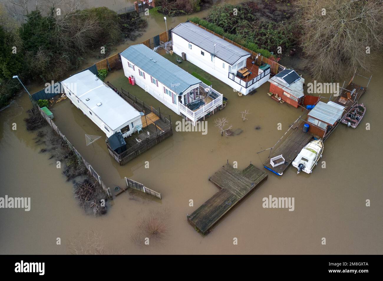 Stourport su Severn, Worcestershire, 14 gennaio 2023 - i siti di carovane lungo il fiume Severn a Stourport su Severn sono stati inondati a causa dell'aumento dell'acqua dopo che il fiume ha scoppiato le sue rive. Una fila di case sul fiume e una piscina per il tempo libero del parco sono mantenute asciutte a causa delle barriere alluvionali e delle pompe dell'acqua. Si prevede che il fiume si innalzi ulteriormente e raggiunga il picco la domenica mattina presto. Credito: Interrompi stampa Media/Alamy Live News Foto Stock