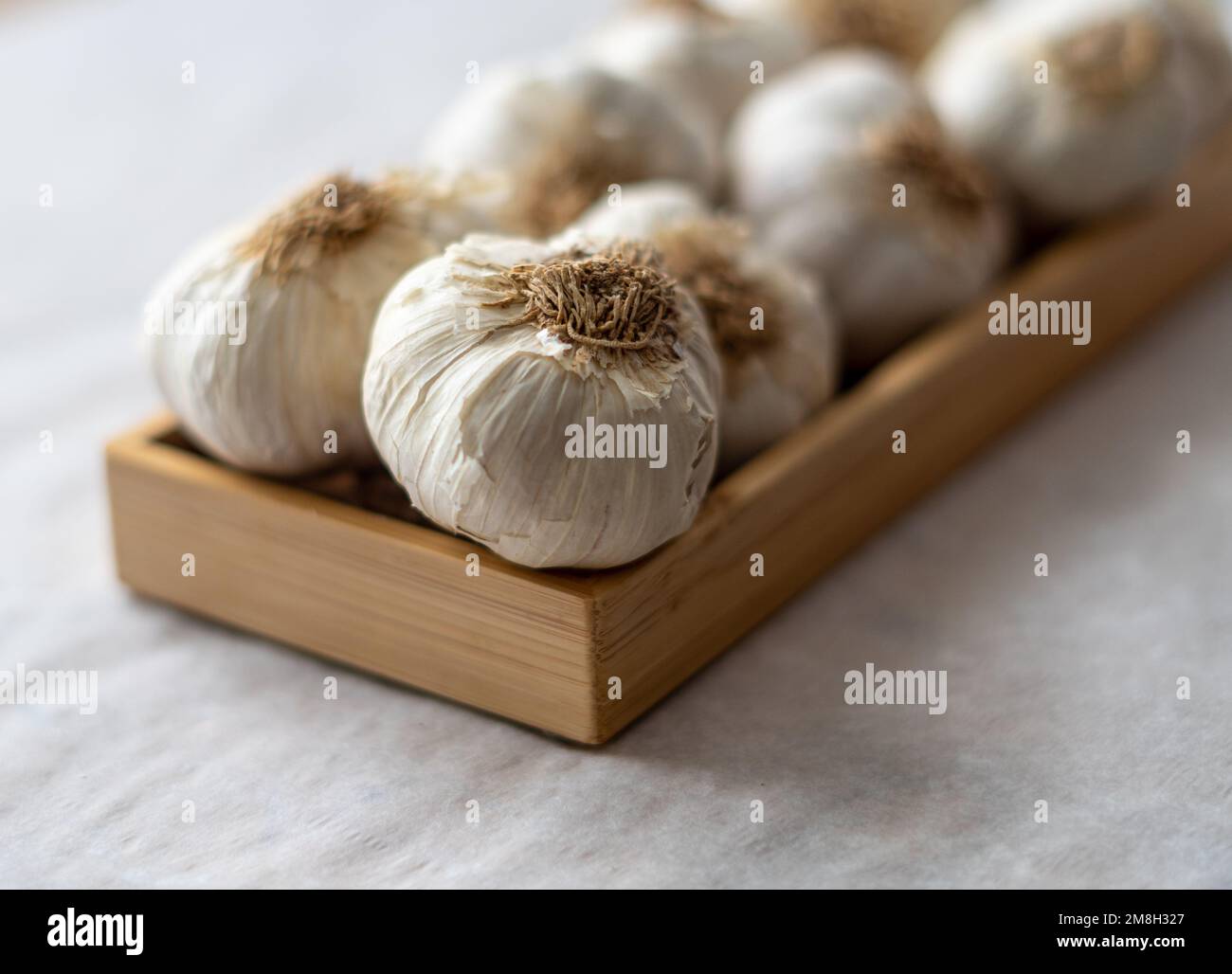 Un fuoco selettivo dello spicchio dei bulbi freschi dell'aglio su un asse di legno Foto Stock