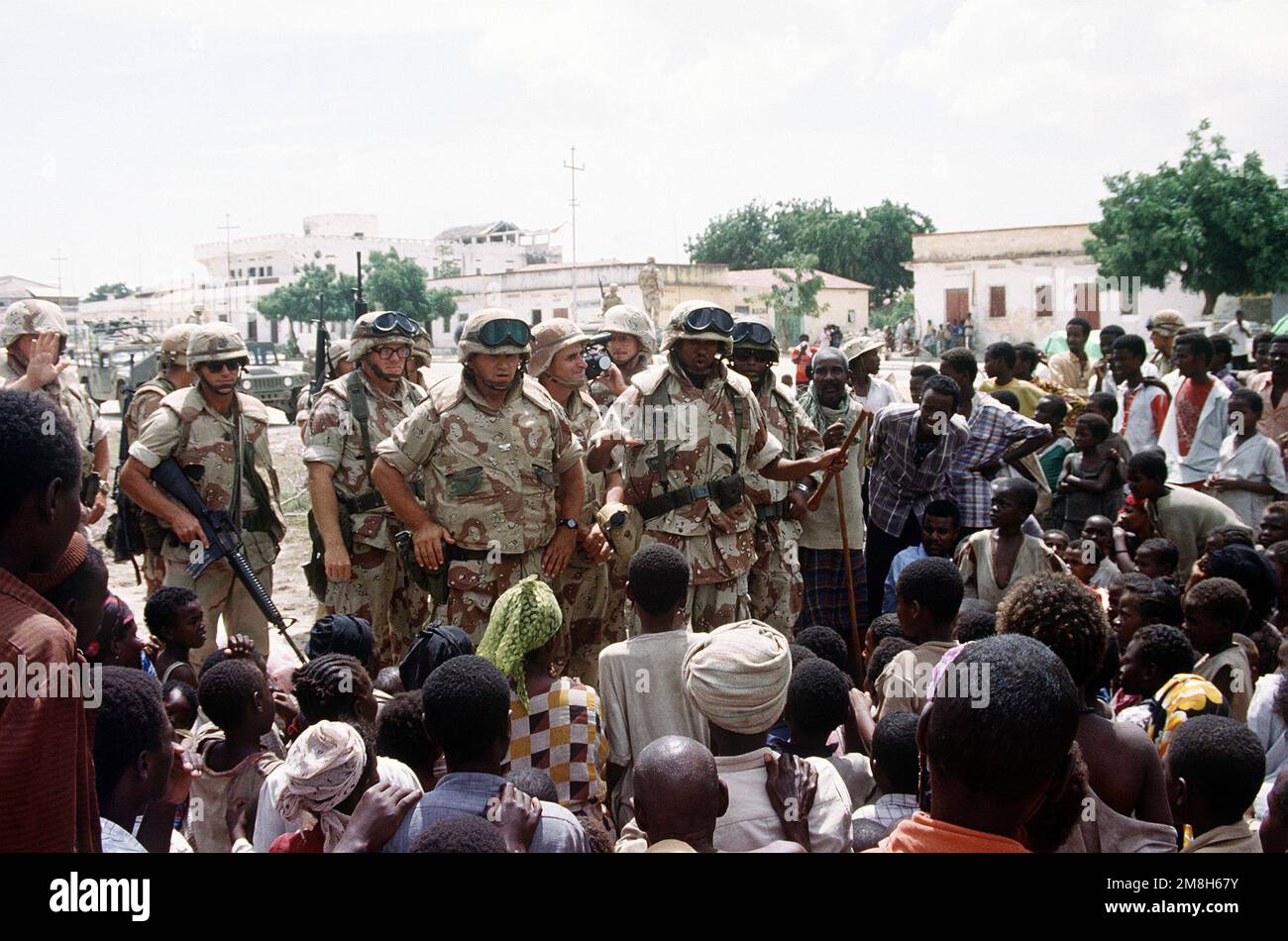 Un colonnello marino si rivolge, con l'aiuto di un interprete, a un gruppo di somali riuniti al di fuori del quartier generale della Joint Task Force Somalia durante l'operazione multinazionale di soccorso Restore Hope. Subject Operation/Series: RESTORE HOPE base: Modadischu Paese: Somalia (SOM) Foto Stock
