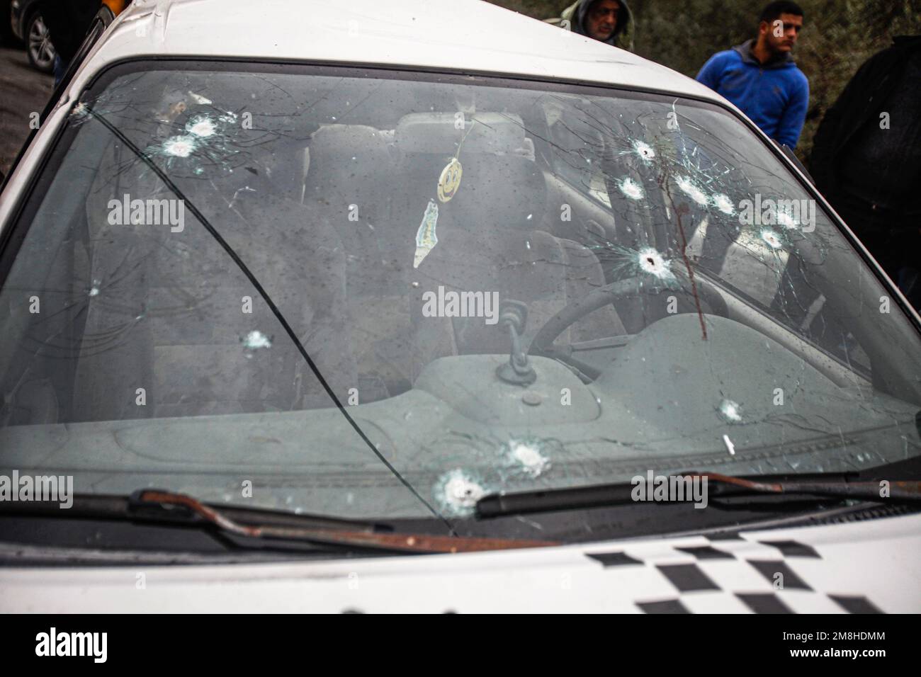 Jenin, Palestina. 14th Jan, 2023. I palestinesi ispezionano l'auto in cui due palestinesi sono stati uccisi dall'esercito israeliano durante il loro inseguimento, dopo aver aperto il fuoco su un posto militare, nella città di Jaba, vicino a Jenin, nella Cisgiordania occupata. Credit: SOPA Images Limited/Alamy Live News Foto Stock