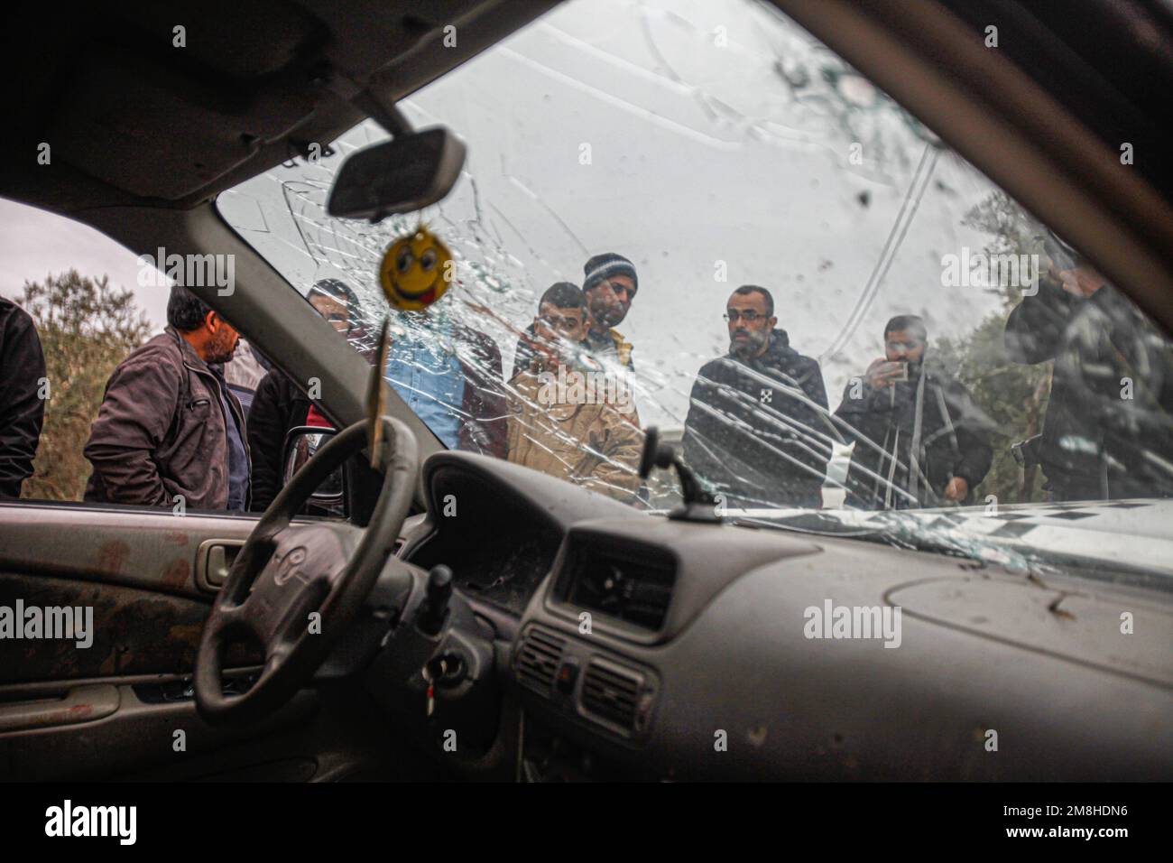 Jenin, Palestina. 14th Jan, 2023. I palestinesi ispezionano l'auto in cui due palestinesi sono stati uccisi dall'esercito israeliano durante il loro inseguimento, dopo aver aperto il fuoco su un posto militare, nella città di Jaba, vicino a Jenin, nella Cisgiordania occupata. Credit: SOPA Images Limited/Alamy Live News Foto Stock