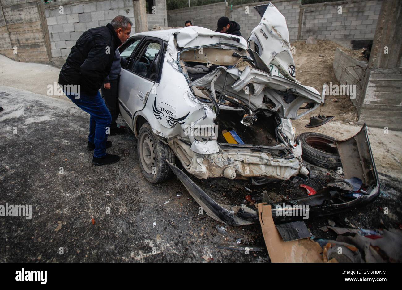 Jenin, Palestina. 14th Jan, 2023. I palestinesi ispezionano l'auto in cui due palestinesi sono stati uccisi dall'esercito israeliano durante il loro inseguimento, dopo aver aperto il fuoco su un posto militare, nella città di Jaba, vicino a Jenin, nella Cisgiordania occupata. Credit: SOPA Images Limited/Alamy Live News Foto Stock