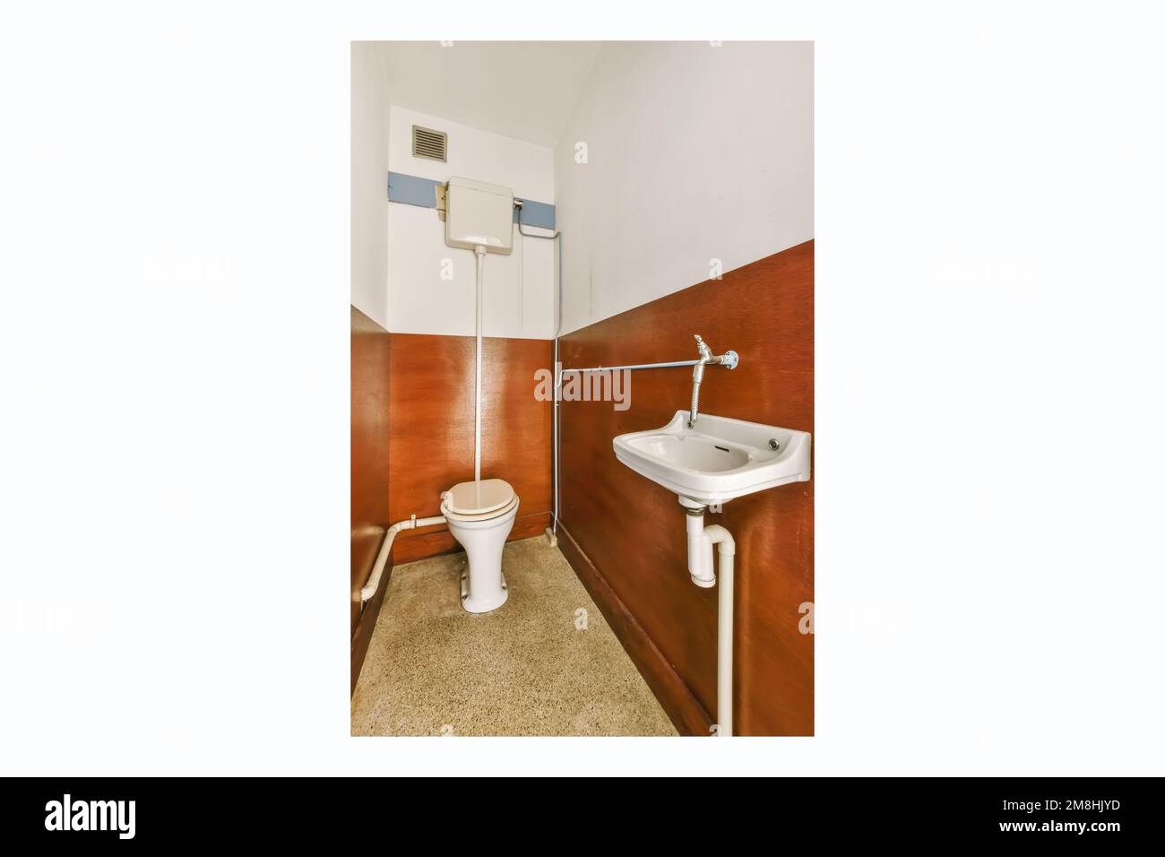 un bagno con lavandino e dispenser di carta igienica attaccati alla parete di fronte allo specchio Foto Stock