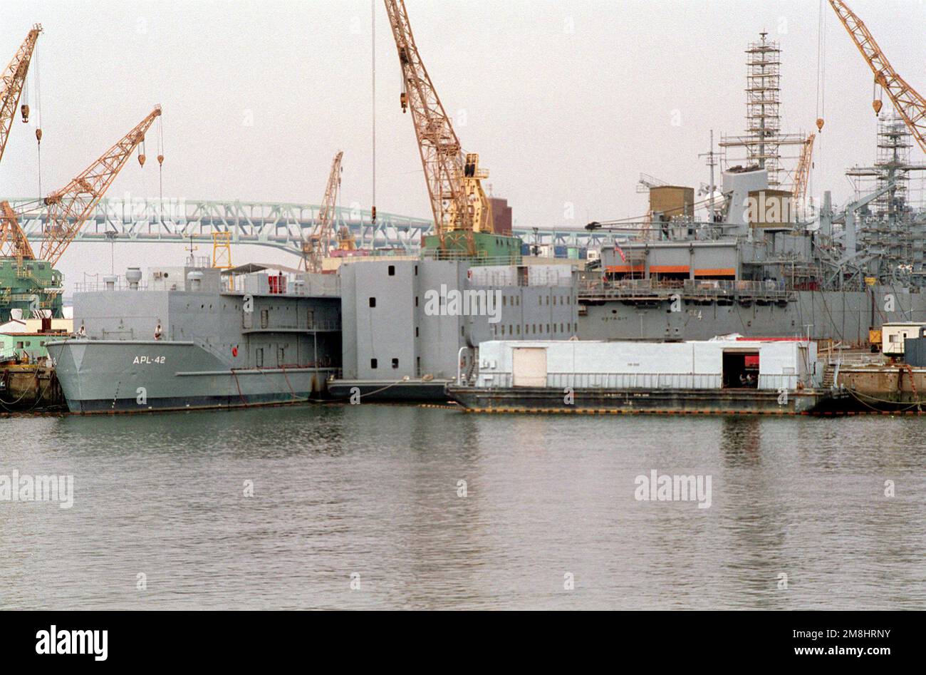 L'imbarcazione di servizio APL-42 e una baracche sono ormeggiate dietro la nave di supporto di combattimento veloce USS DETROIT (AOE-4) mentre subisce una revisione di routine presso il cantiere navale di Philadelphia. Base: Naval Shipyard Stato: Pennsylvania (PA) Paese: Stati Uniti d'America (USA) Foto Stock