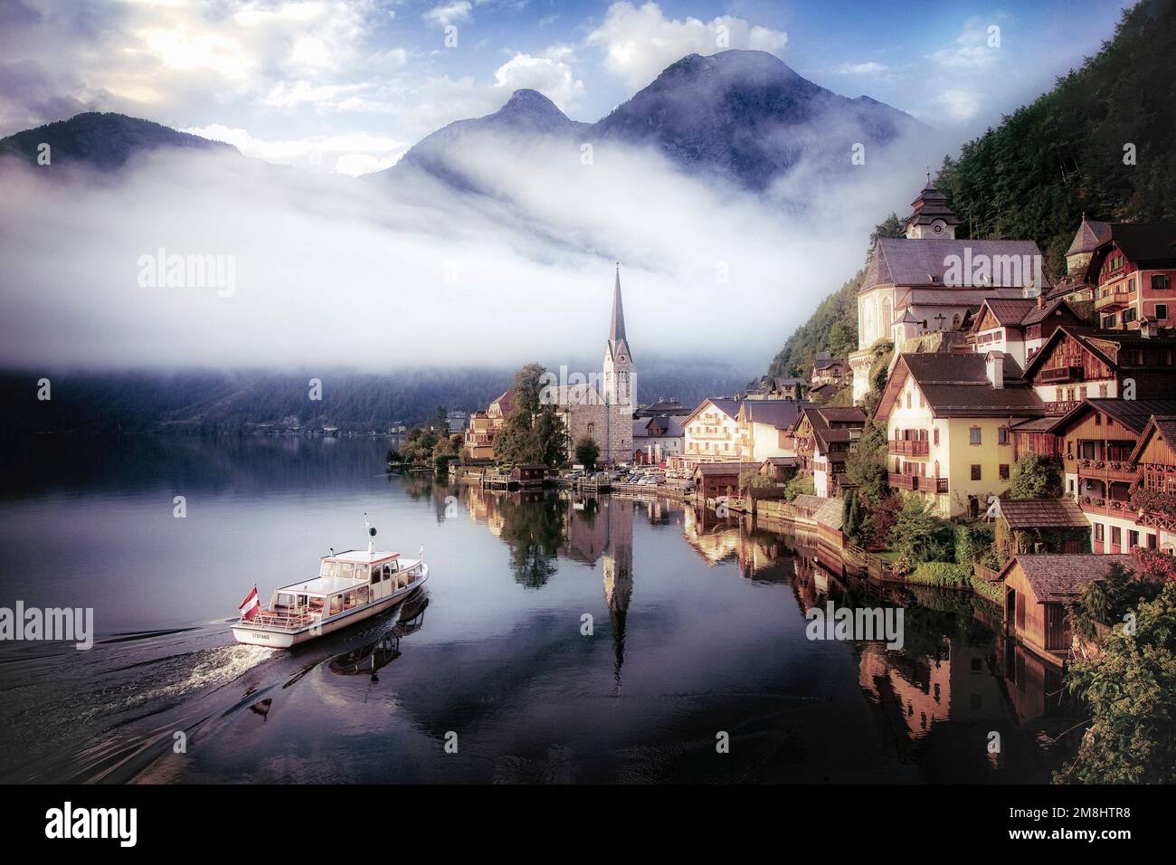 Un taxi d'acqua si avvicina al piccolo villaggio storico di Hallstatt, Austria. Foto Stock